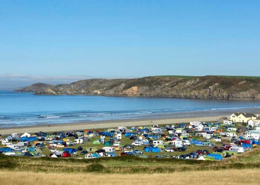 Looking down on the campsite at Newgale packed full of tents and vans on a busy bank holiday and out to sea at Newgale